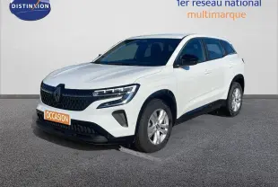 Renault Austral blanc glacier en 3/4 avant droit avec calandre noire et jantes alliage argentées visible sur sol gris.