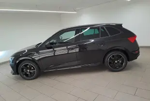 Vue latérale droite d'une Skoda Scala 1.0 TSI Monte-Carlo noire nacrée, avec jantes noires et intérieur visible.