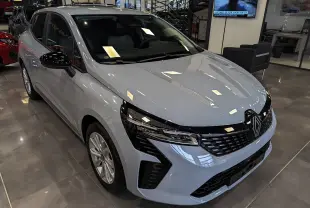 Renault Clio V Blue dCi 100 Gris Rafale vue 3/4 avant en intérieur, avec calandre noire et jantes alliage.