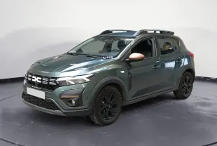 Vue 3/4 avant droit d'une Dacia Sandero Stepway 2024 vert cèdre avec jantes noires et rétroviseurs brun cuivré.