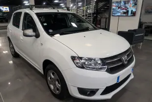 Vue 3/4 avant gauche d'une Dacia Sandero TCe 90 blanche Glacier, avec jantes alliage et calandre noire en showroom.
