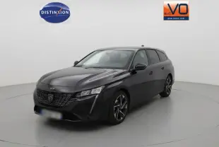 Peugeot 308 SW Hybrid noir vue 3/4 avant droit, avec calandre distinctive et phares LED fins.