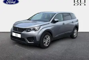 Peugeot 5008 gris Artense en 3/4 avant droit, SUV familial avec jantes alu et barres de toit visibles.