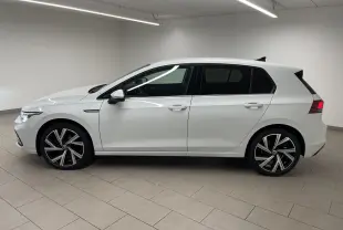 Profil côté gauche d'une Volkswagen Golf 1.5 eTSI Style blanche avec jantes Bergamo et vitres arrière surteintées.