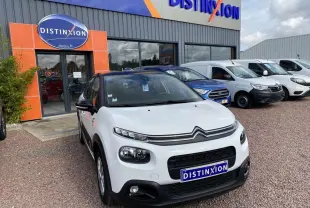 Citroën C3 blanc vue 3/4 avant avec toit noir, stationnée devant un concessionnaire Distinxion.