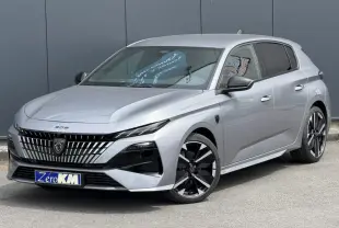 Peugeot 308 gris Artense vue 3/4 avant, avec calandre noire distinctive et jantes alliage bi-ton.
