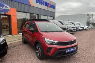 Opel Crossland rouge métallisé en 3/4 avant droit, avec feux LED et calandre noire, stationné devant un concessionnaire.