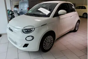 Vue 3/4 avant d'une FIAT 500 électrique blanche, avec logo distinctif et jantes multibranches visibles.