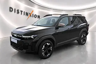 SUV Dacia Bigster noir en 3/4 avant droit, avec jantes alu et barres de toit visibles en showroom lumineux.