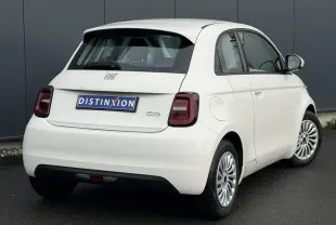 Fiat 500 électrique blanche vue 3/4 avant droit, avec jantes multibranches et calandre épurée.