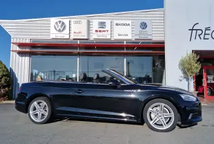 Audi A5 Cabriolet noir vue de profil côté gauche, capote ouverte, jantes alliage cinq branches visibles.