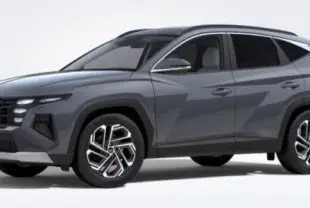 Vue 3/4 avant d'un Hyundai Tucson 2025 gris Ecotronic, avec calandre imposante et jantes bi-ton visibles.