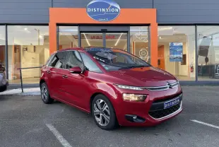 Citroën C4 Picasso rouge foncé vue 3/4 avant droit devant un showroom Distinxion.
