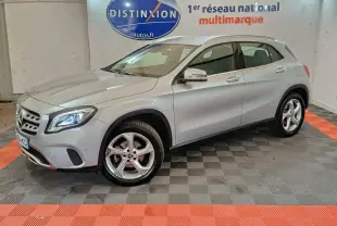 Mercedes GLA 200 d gris clair vue 3/4 avant droit, avec jantes alliage et feux LED allumés en intérieur showroom.
