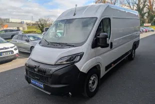 Vue 3/4 avant d’un Peugeot Boxer Fourgon blanc, avec calandre noire et rétroviseurs noirs, stationné en extérieur.
