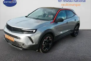 Opel Mokka GS Line gris quartz en 3/4 avant droit avec toit noir et détails rouges sur les jantes et montant de porte.