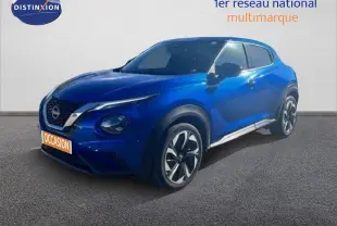 Nissan Juke bleu magnétique en 3/4 avant droit, avec jantes alliage et calandre distinctive V-Motion.