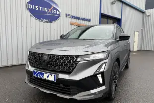 Vue 3/4 avant droit du Renault Austral gris schiste avec toit noir et calandre noire distinctive sous la pluie.