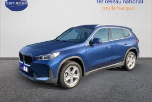 BMW X1 18I 136CH bleu Phytonic metal en 3/4 avant droit, mettant en valeur sa calandre et ses jantes argentées.