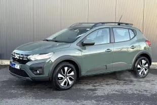 Dacia Sandero Stepway 2025 kaki lichen en 3/4 avant droit avec barres de toit et jantes spécifiques.