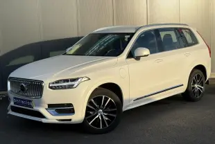 Vue 3/4 avant droite du Volvo XC90 blanc Crystal avec jantes alliage noires et chrome autour des vitres.