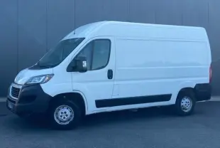 Vue de profil côté gauche d’un Peugeot Boxer Fourgon blanc avec porte latérale coulissante et jantes acier.