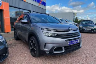 SUV Citroën C5 Aircross gris Artense vu en 3/4 avant droit avec calandre distinctive et jantes noires.