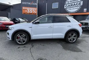 Volkswagen T-Roc blanc vue de profil côté gauche, jantes alliage 18 pouces et détails R-Line visibles.