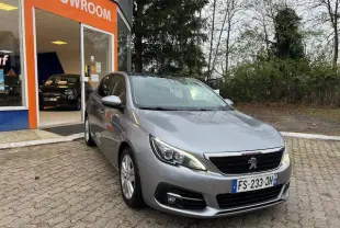 Peugeot 308 gris artense vue 3/4 avant droit devant un showroom avec toit panoramique en verre.