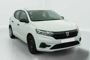Vue 3/4 avant d'une Dacia Sandero blanche avec calandre noire et jantes tôles 15 pouces.