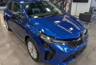 Renault Clio V Blue dCi 100 en bleu Iron, vue 3/4 avant droit, avec calandre noire et phares LED distinctifs.