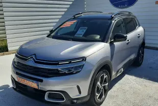 Citroën C5 Aircross gris Artense avec toit noir, vue 3/4 avant droit, jantes bi-ton et barres de toit visibles.
