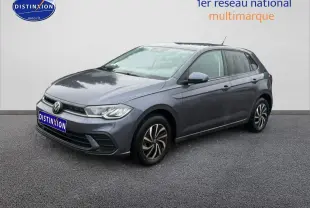 Volkswagen Polo gris cendre vue 3/4 avant droit sur sol gris avec calandre noire et jantes alliage.