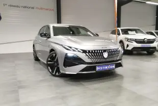 Vue 3/4 avant d'une Peugeot 308 gris Artense avec calandre lumineuse et jantes alliage noires en showroom.