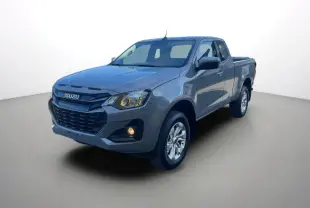 Vue 3/4 avant droit d'un pick-up Isuzu D-MAX gris Kinabalu avec jantes alu et phares allumés.