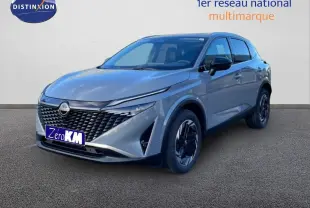 Nissan Qashqai 2025 gris argile métal en 3/4 avant droit, avec calandre noire et jantes bicolores.