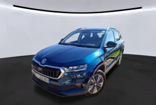 Vue 3/4 avant droite d'un Skoda Karoq bleu 2023 avec calandre chromée et jantes alu 17 pouces en intérieur.