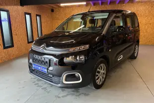 Vue 3/4 avant droit d'un Citroën Berlingo noir 2020, avec calandre distinctive et phares modernes dans un garage.