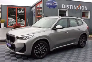 BMW X1 U11 xDrive 20d 2024 argent métallisé en 3/4 avant droit, avec jantes alliage et calandre noire M Sport.