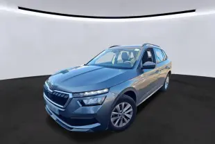 Vue 3/4 avant droite d'un Skoda Kamiq gris foncé 2023 avec calandre distinctive et toit ouvrant visible.
