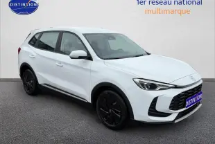 MG ZS Hybrid blanc vu en 3/4 avant droit avec jantes noires et calandre imposante noire.