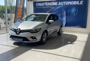 Renault Clio 2018 gris platine vue 3/4 avant droit dans showroom avec bannière Chanteraine Automobile en arrière-plan