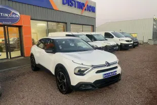 Citroën C4 blanc vue 3/4 avant droit, toit noir et jantes noires, devant concession Distinxion.