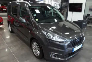 Ford Grand Tourneo Connect gris Magnetic en 3/4 avant droit dans un showroom lumineux avec jantes alliage.