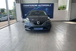Vue frontale d'une Renault Mégane gris Titanium 2022 exposée en showroom avec logo Renault bien visible sur la calandre.