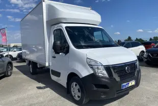 Vue 3/4 avant droite d’un utilitaire Nissan Interstar blanc avec capucine, stationné en extérieur sous ciel bleu.