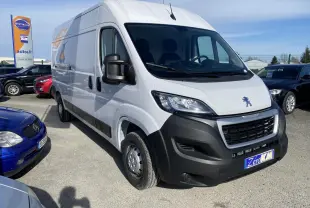 Vue 3/4 avant droite d'un Peugeot Boxer Fourgon blanc 2022 avec pare-chocs noirs et porte latérale coulissante.