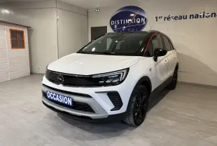 Opel Crossland blanc en 3/4 avant droit avec toit noir et jantes noires dans un showroom intérieur.