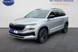 Vue 3/4 avant d'un Skoda Karoq gris argent métallisé avec jantes noires et calandre noire sportive.