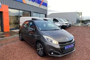 PEUGEOT 208 gris métallisé vue 3/4 avant droit, avec phares allumés et jantes alliage 16 pouces titane.